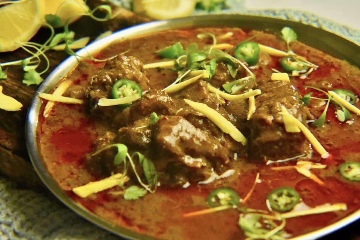 Nihari topped with ginger, chopped green chilies and cilantro microgreens.