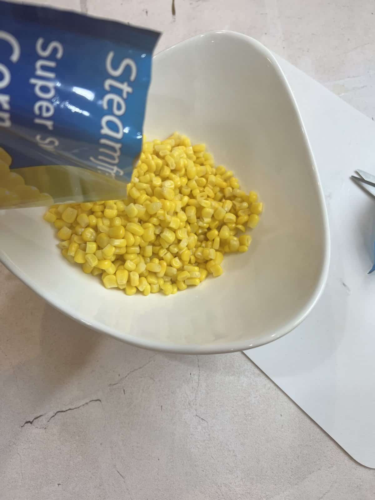 white bowl with yellow sweet corn kernel.