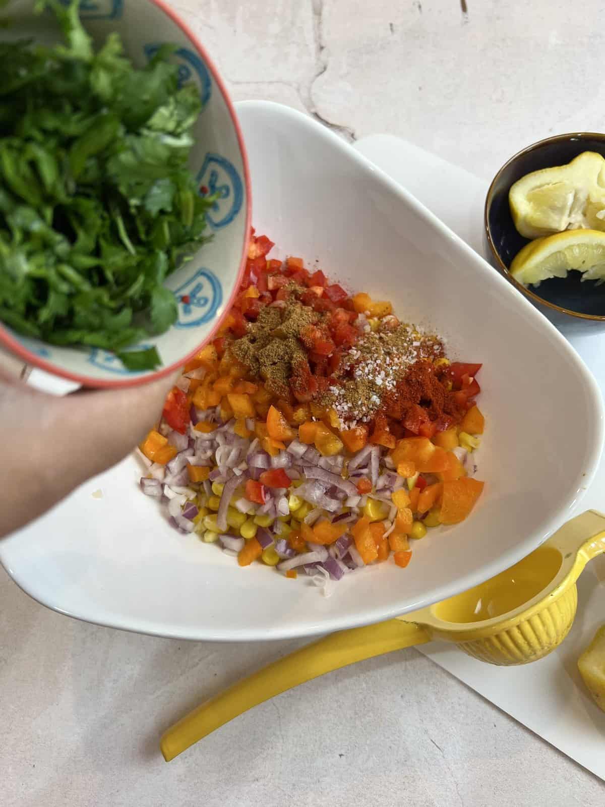 mixed corn salad with a bowl of cilantro.