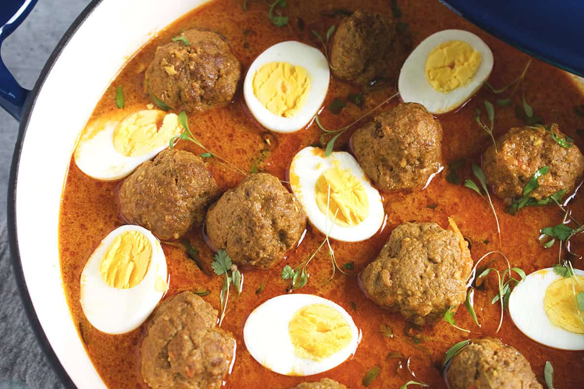 A freshly cooked beef meatball curry is in a blue and white skillet.