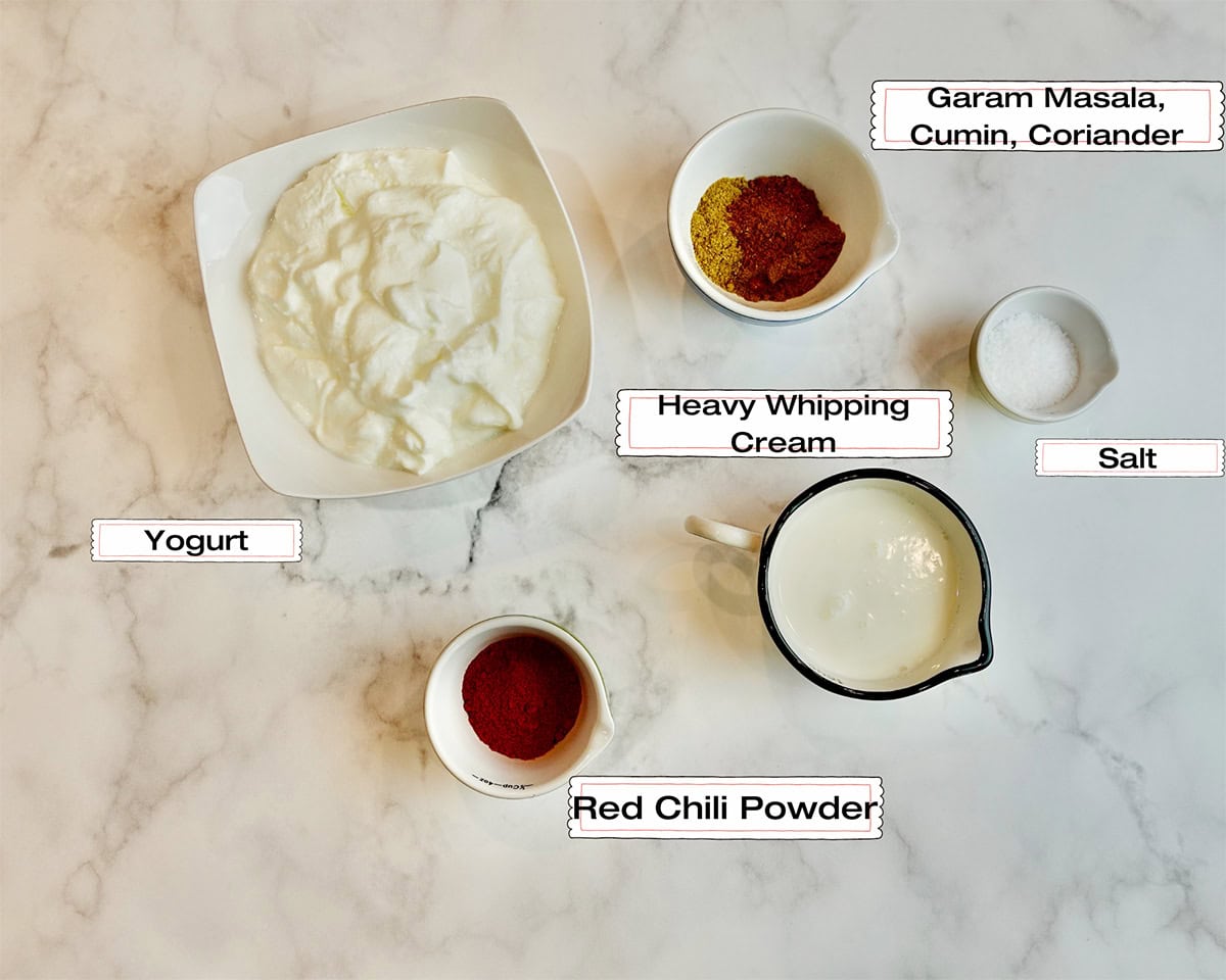 The measured ingredients to make a sauce for murgh makhani  are resting on a white kitchen counter.