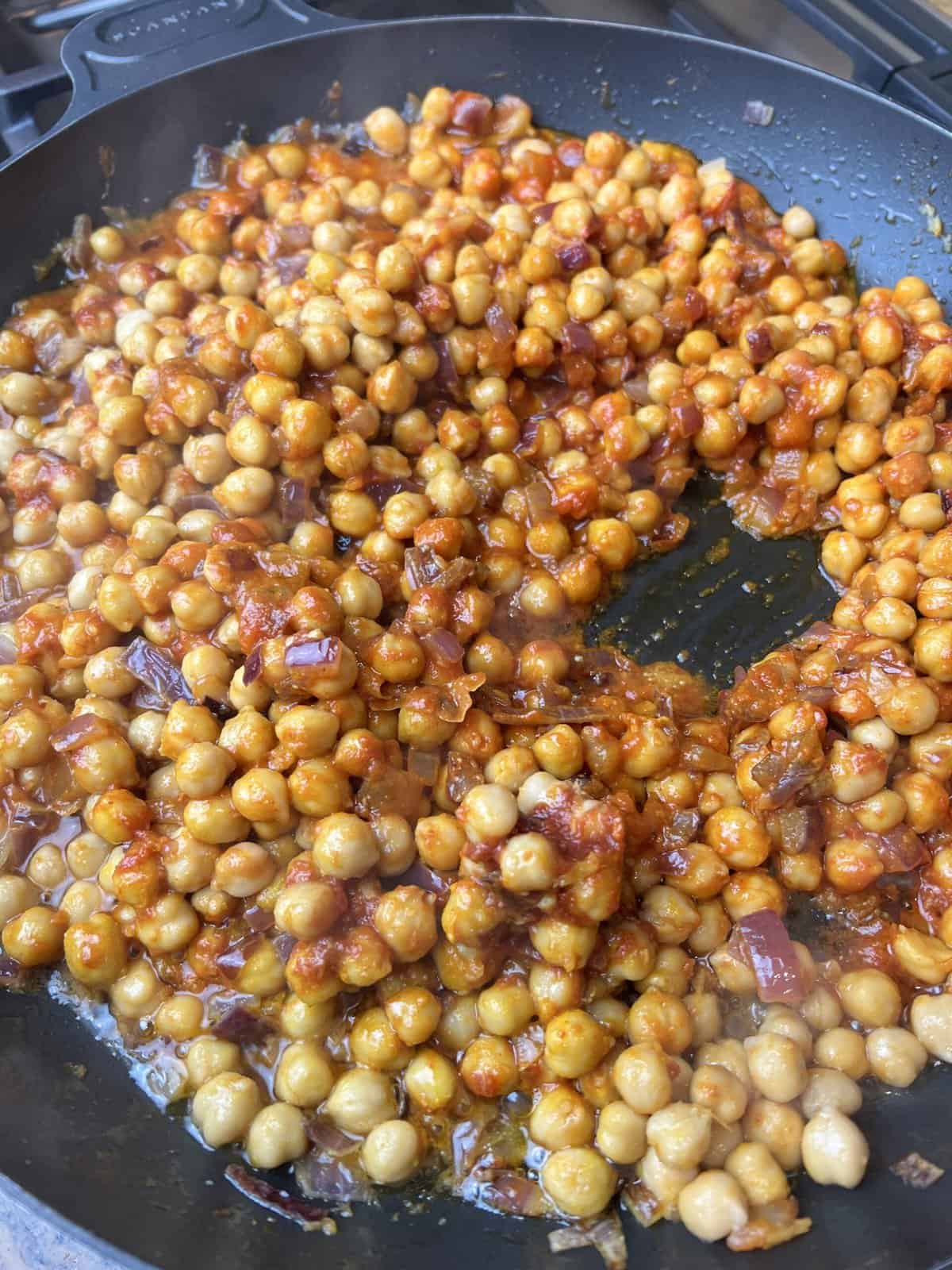 black pan with chana masala and water.