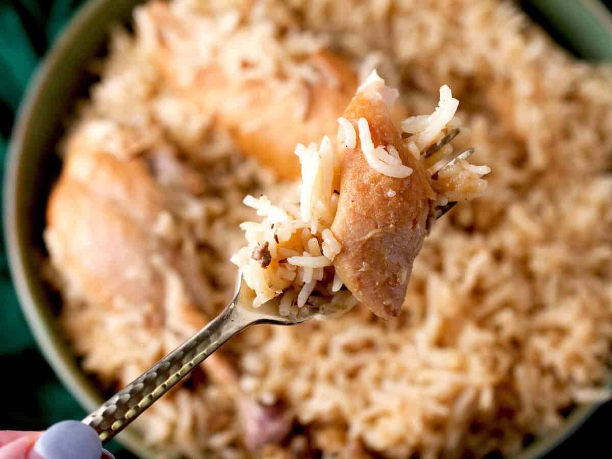 A fork full of chicken and rice.
