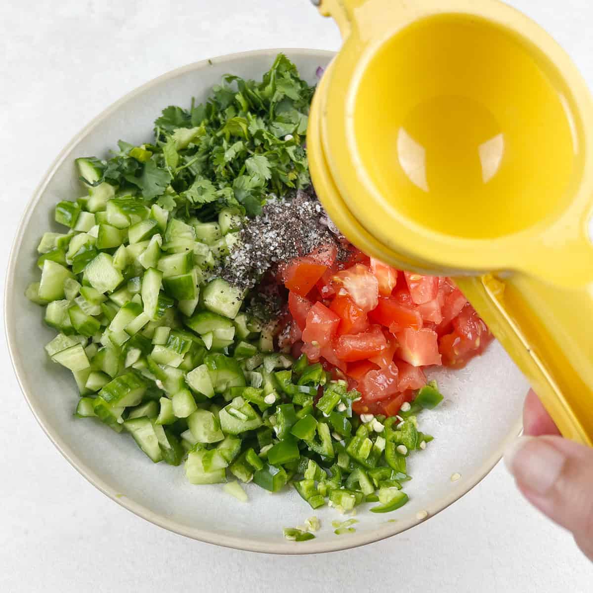 lemon being squeezed over a salad.