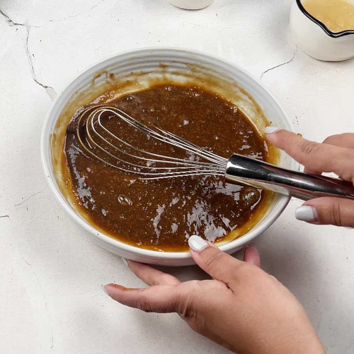 An oil and dark brown sugar mixture being prepped for a cake recipe.