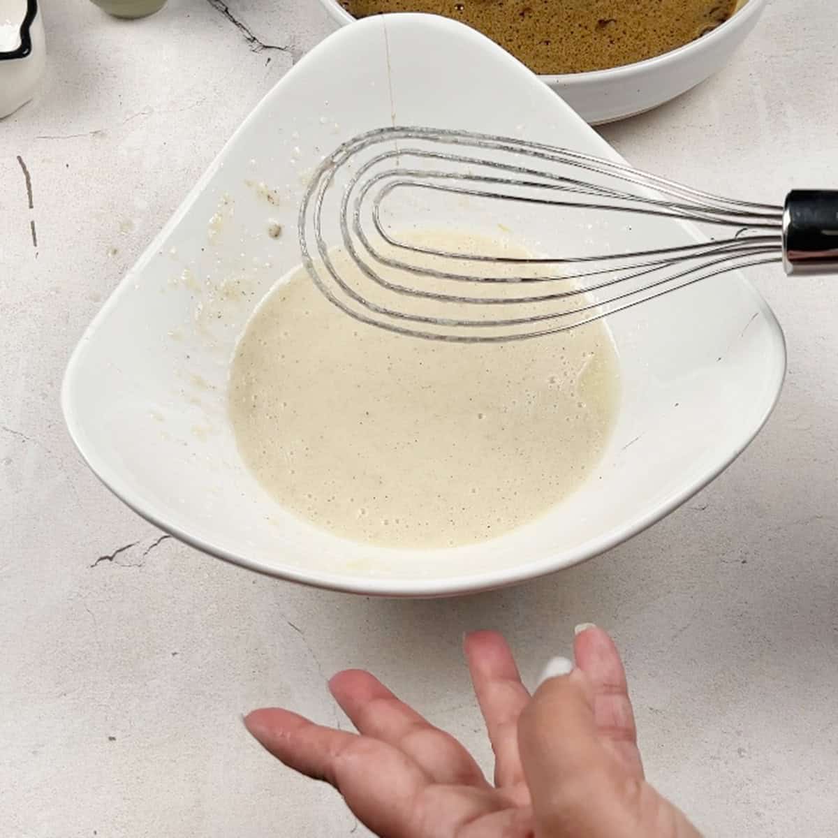 A liquid mixture is being whisked for a cake 
recipe.