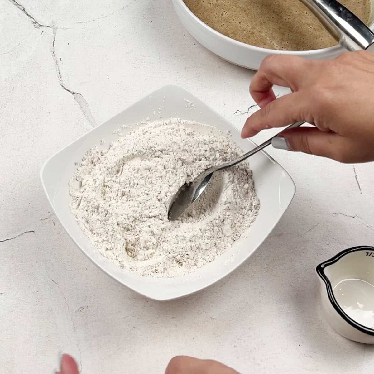 flour and other dry ingredients for a mini bundt cake recipe are being mixed together.