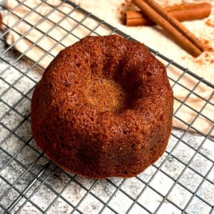 A freshly baked holiday spiced bundt cake is cooling on a rack.