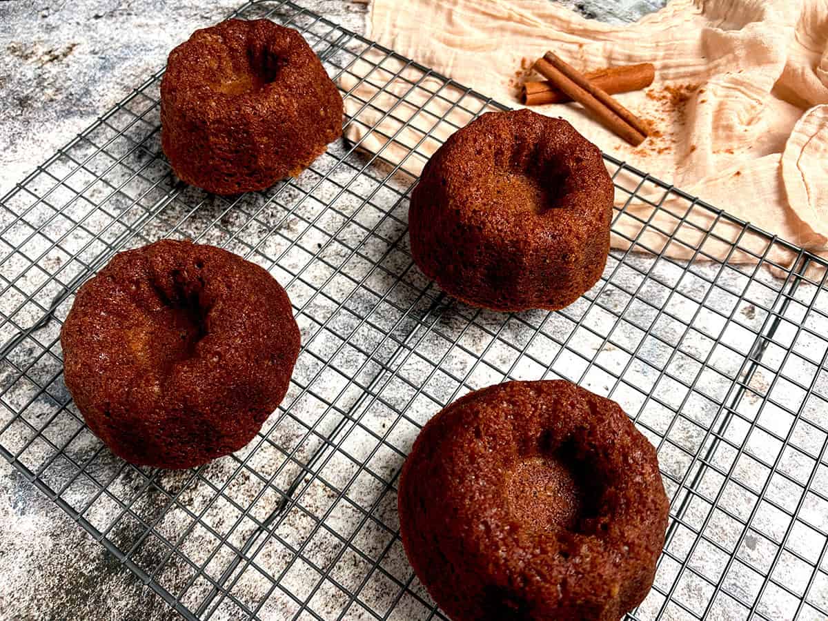 mini bundt cakes with holiday spices on a cooling rack.