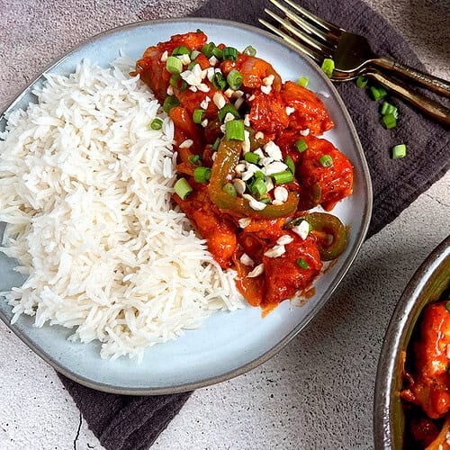 A gray plate is filled with a spicy and crispy chili chicken recipe.