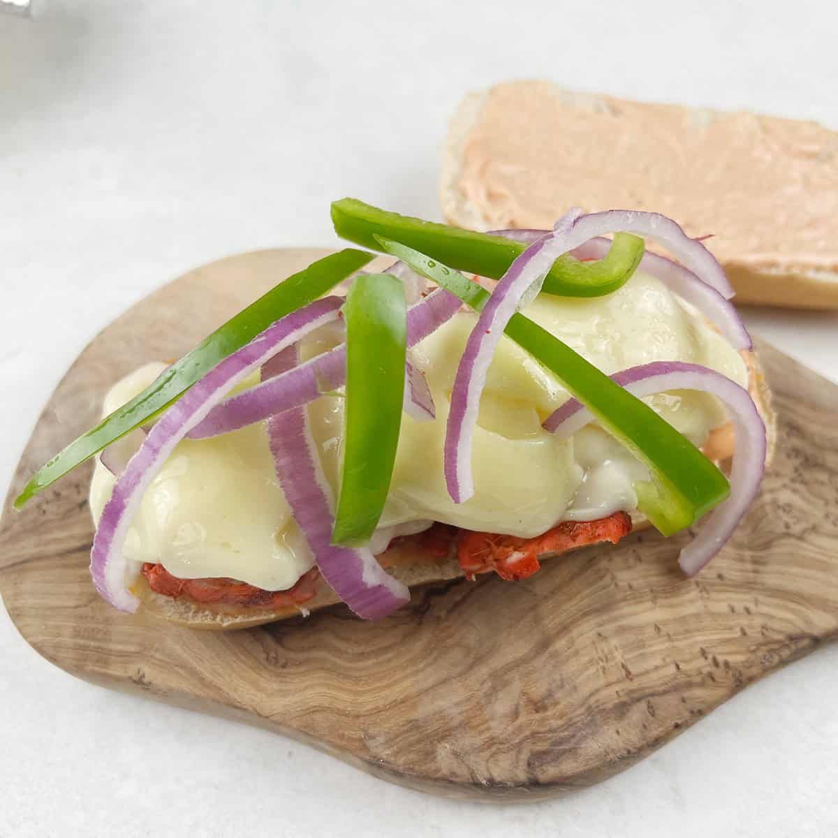 Onions and peppers on a sandwich.