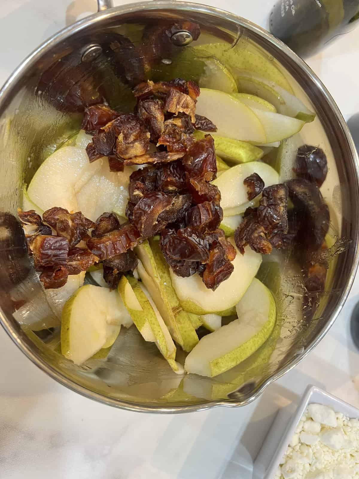 sliced pears and chopped dates in a metal bowl.