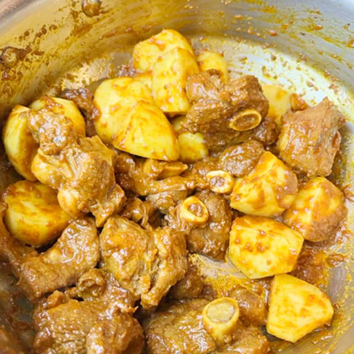 Aloo gosht in a pot on the stove.