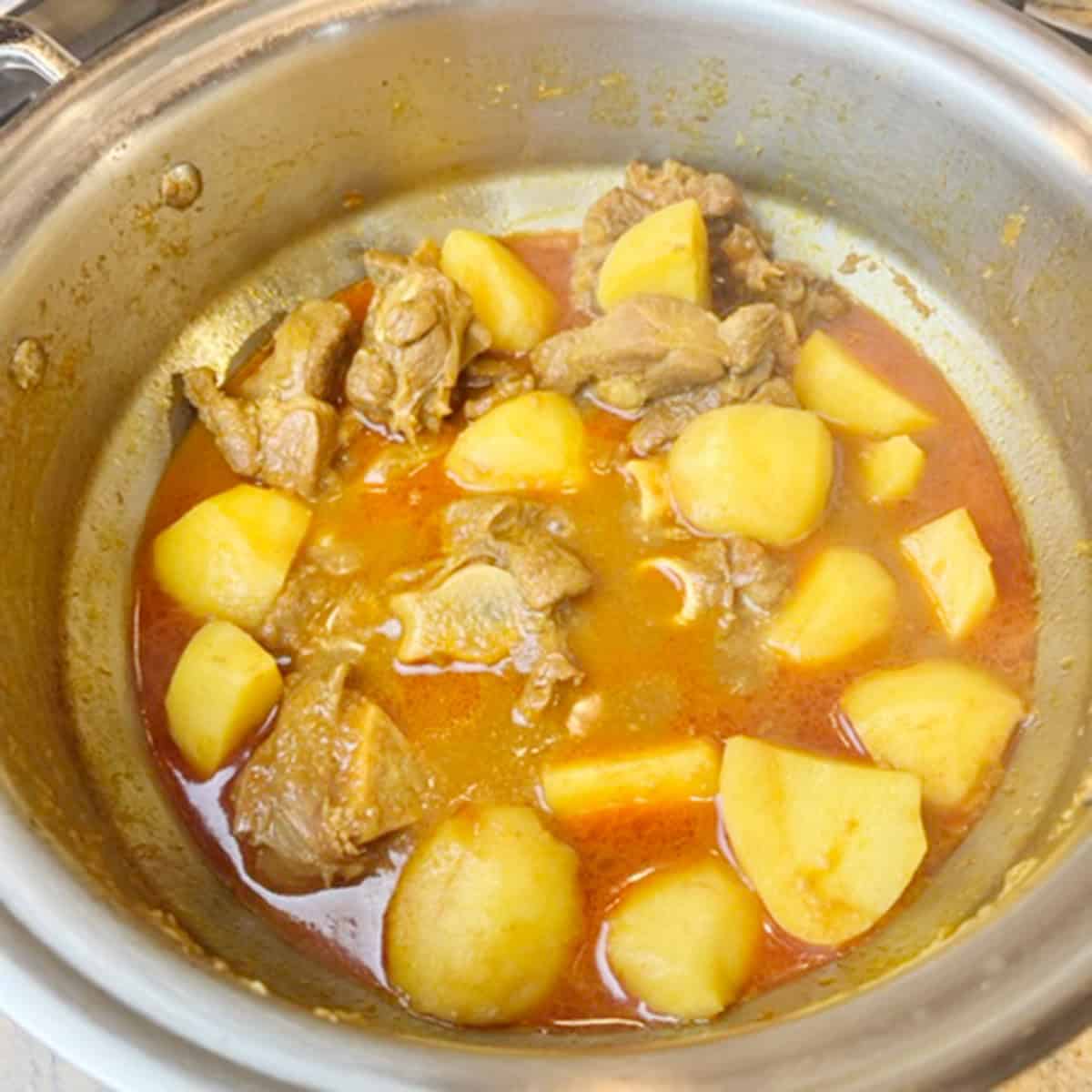 Meat and potato curry being cooked.