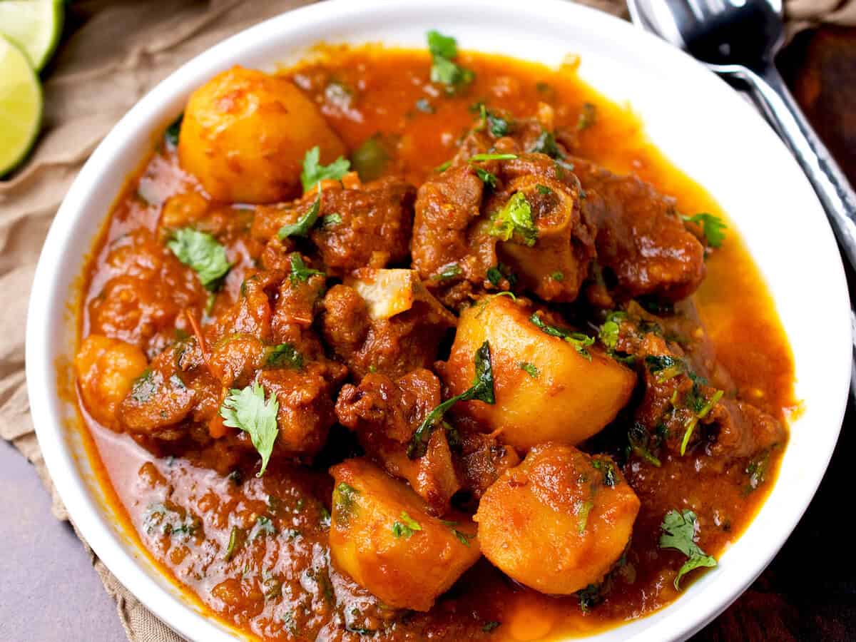 Aloo gosht garnished with cilantro.