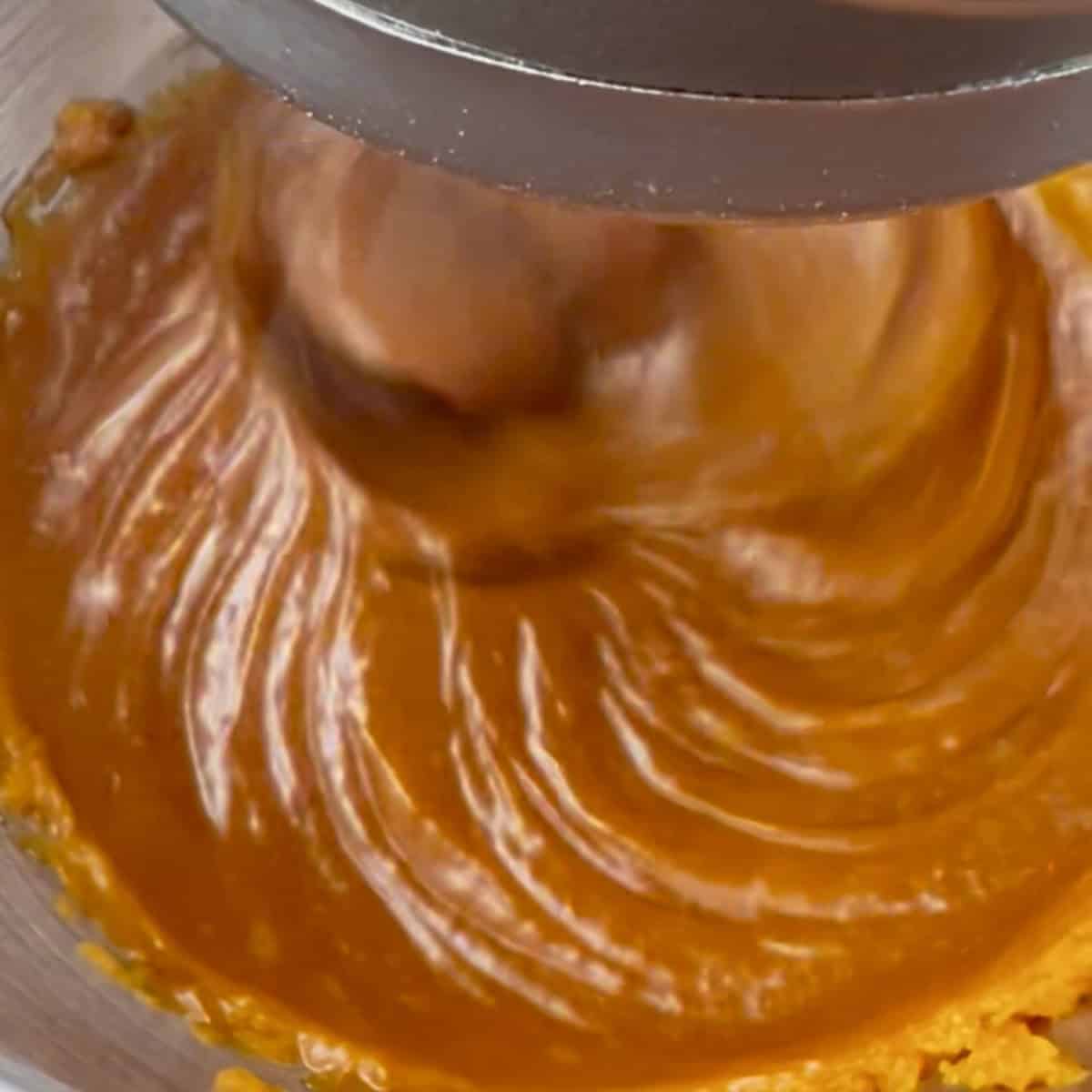 Pumpkin, oil, and sugar being mixed for a fall recipe.