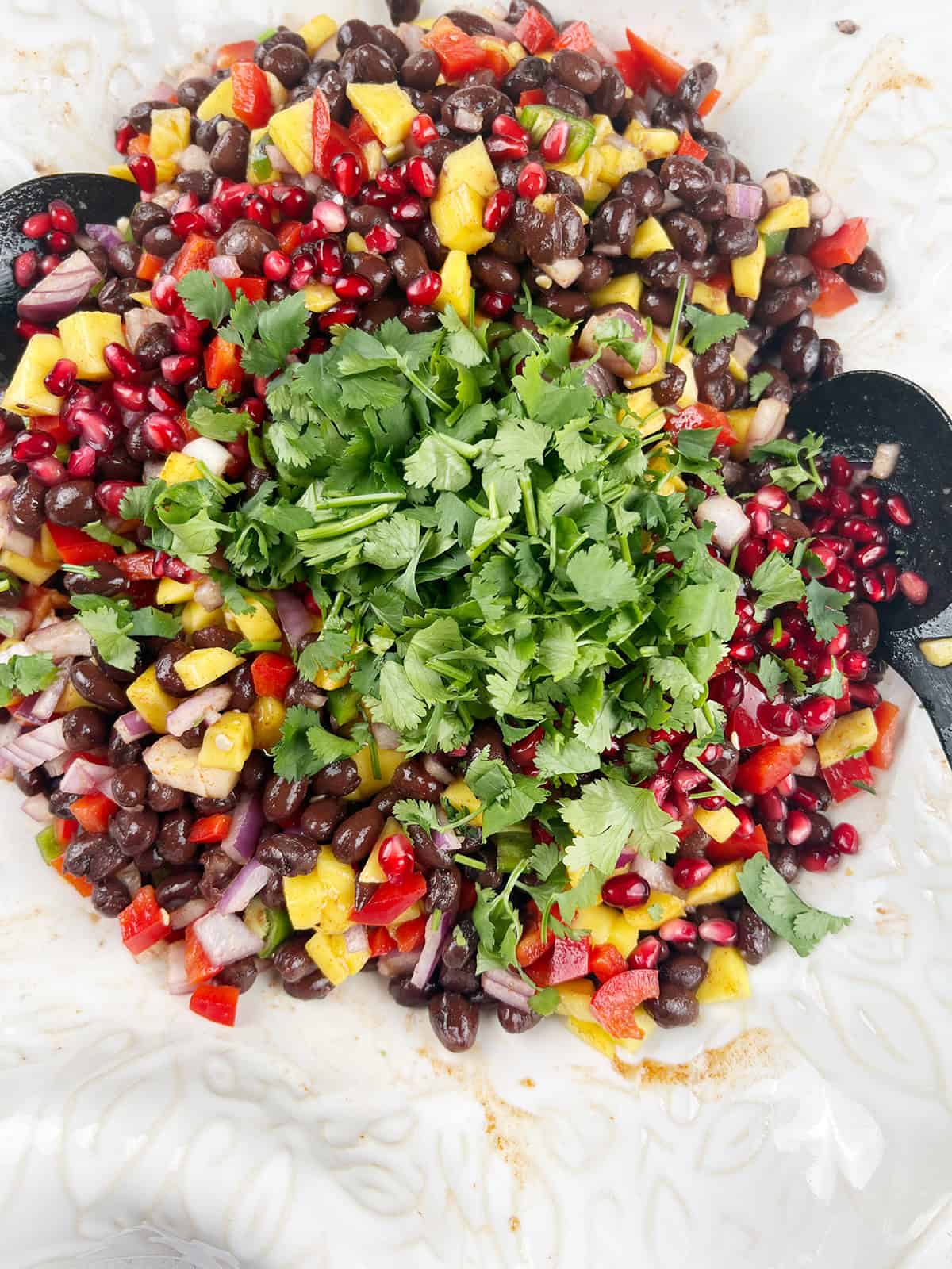 Chopped cilantro is added to a bean salad.