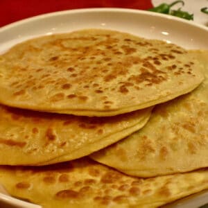 white plate with aloo parathas.