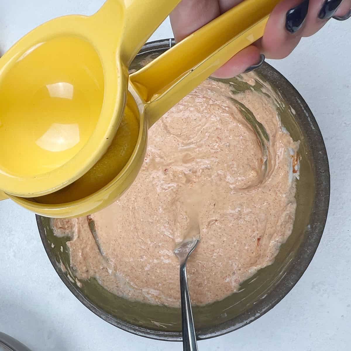 Lemon juice is being added to a prepared marinade.