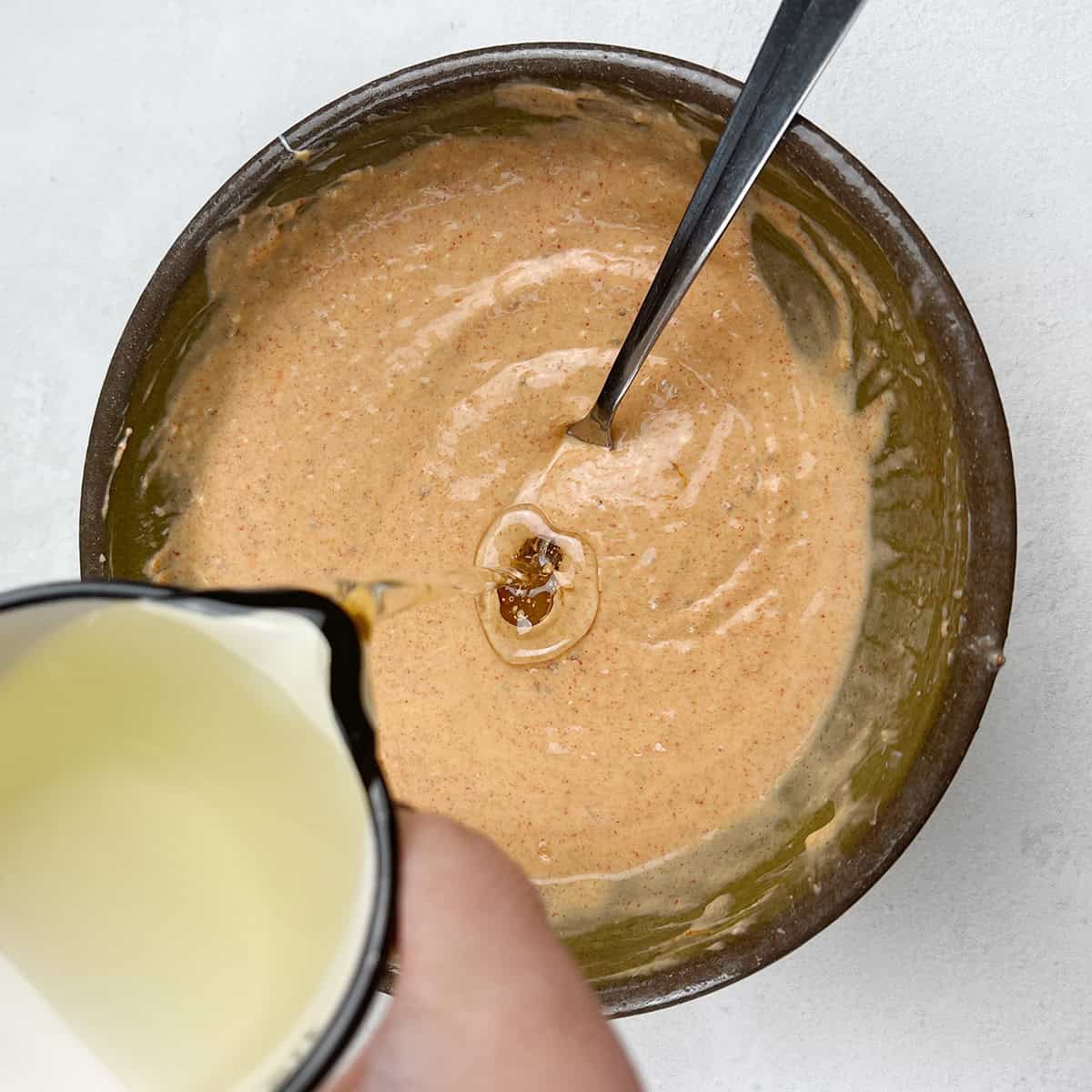 Oil is being added to a tandoori shrimp marinade.