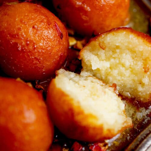 A plate of gulab jamun, with one cut in half.