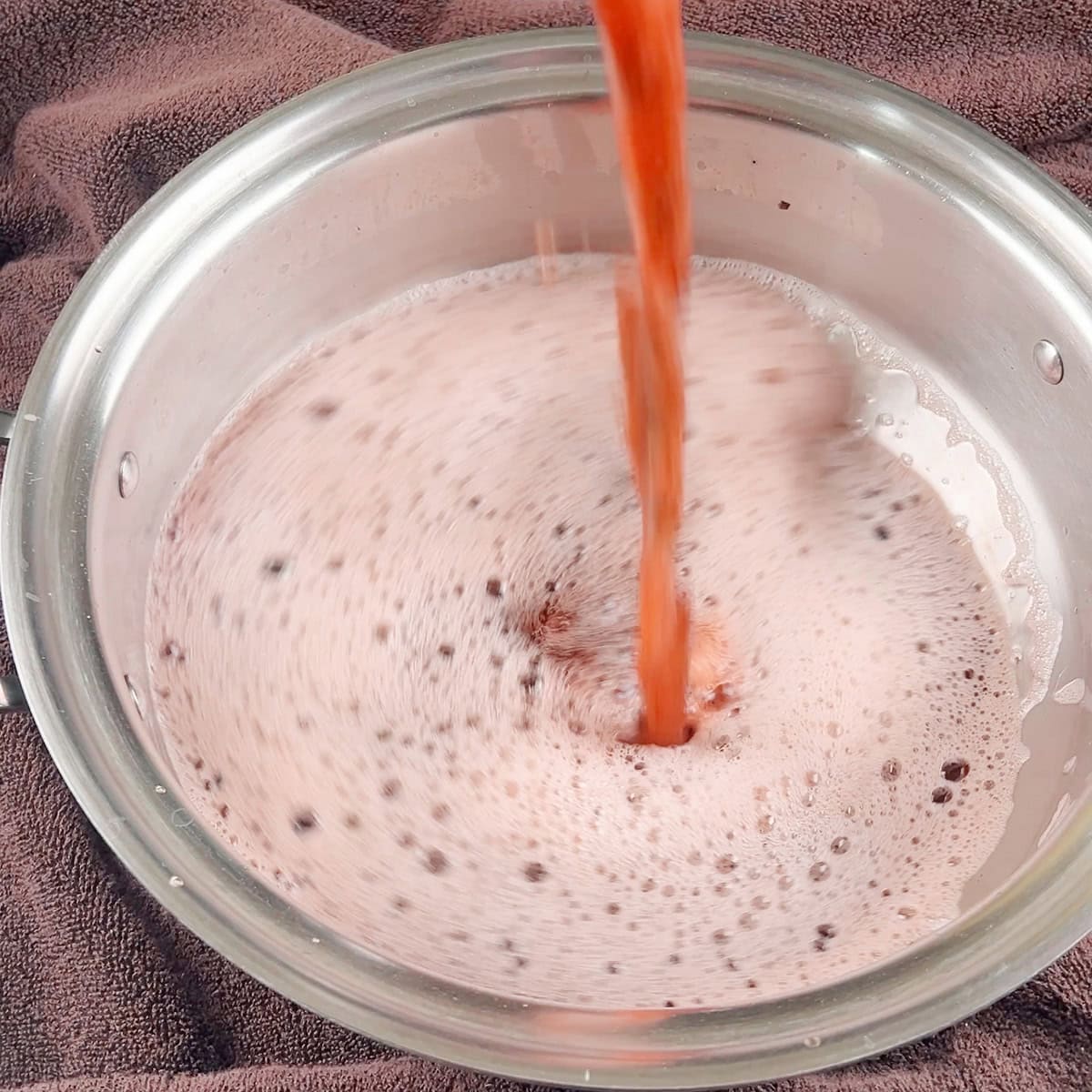 A Pakistani pink tea mixture is being aerated.