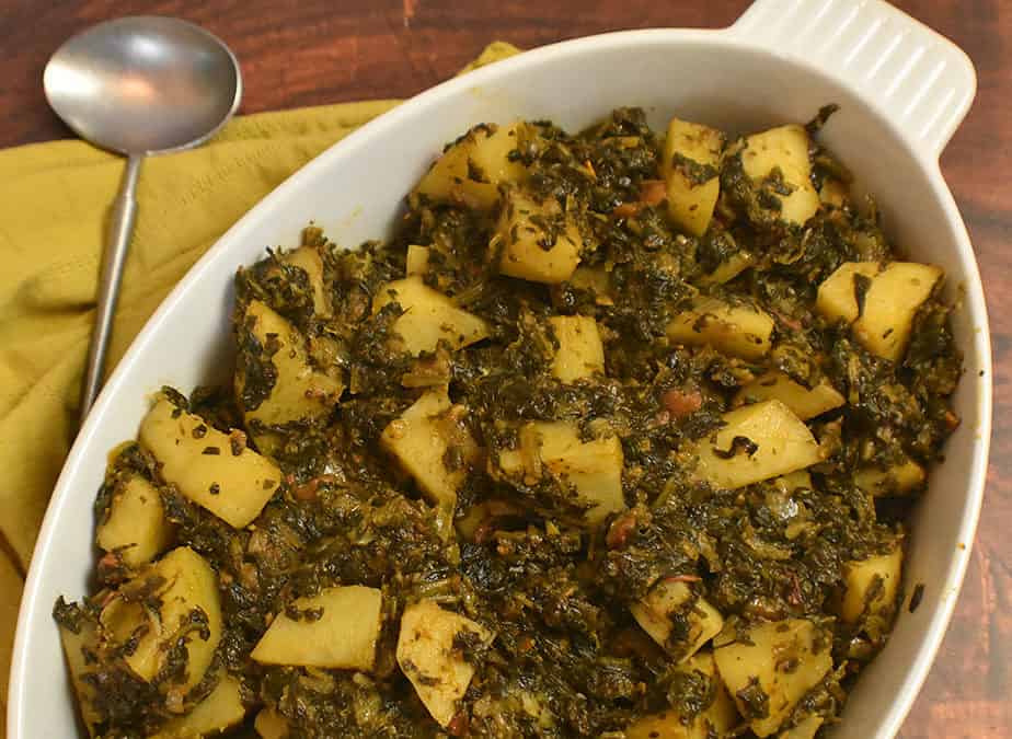 cooked aloo palak in a white serving dish.