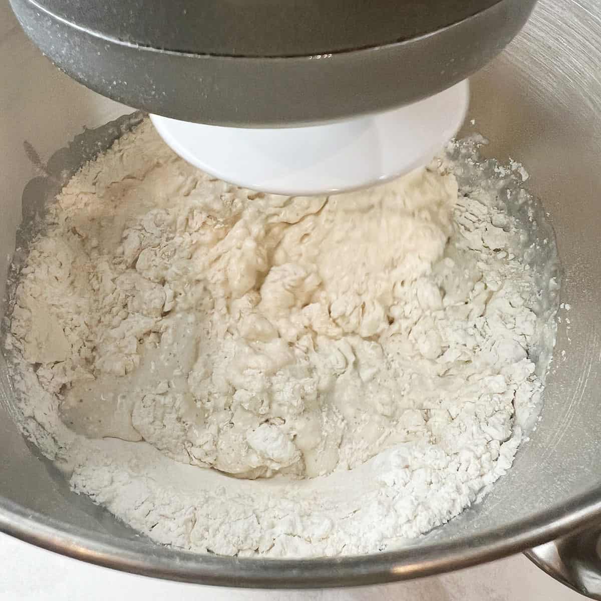 A kitchen Aid mixer is being used to mix a dough for an easy naan recipe.