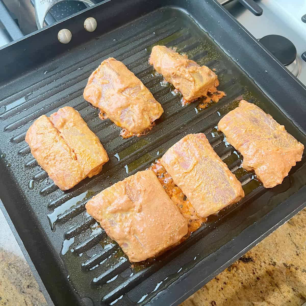 Fish filets being cooked in a grill pan.