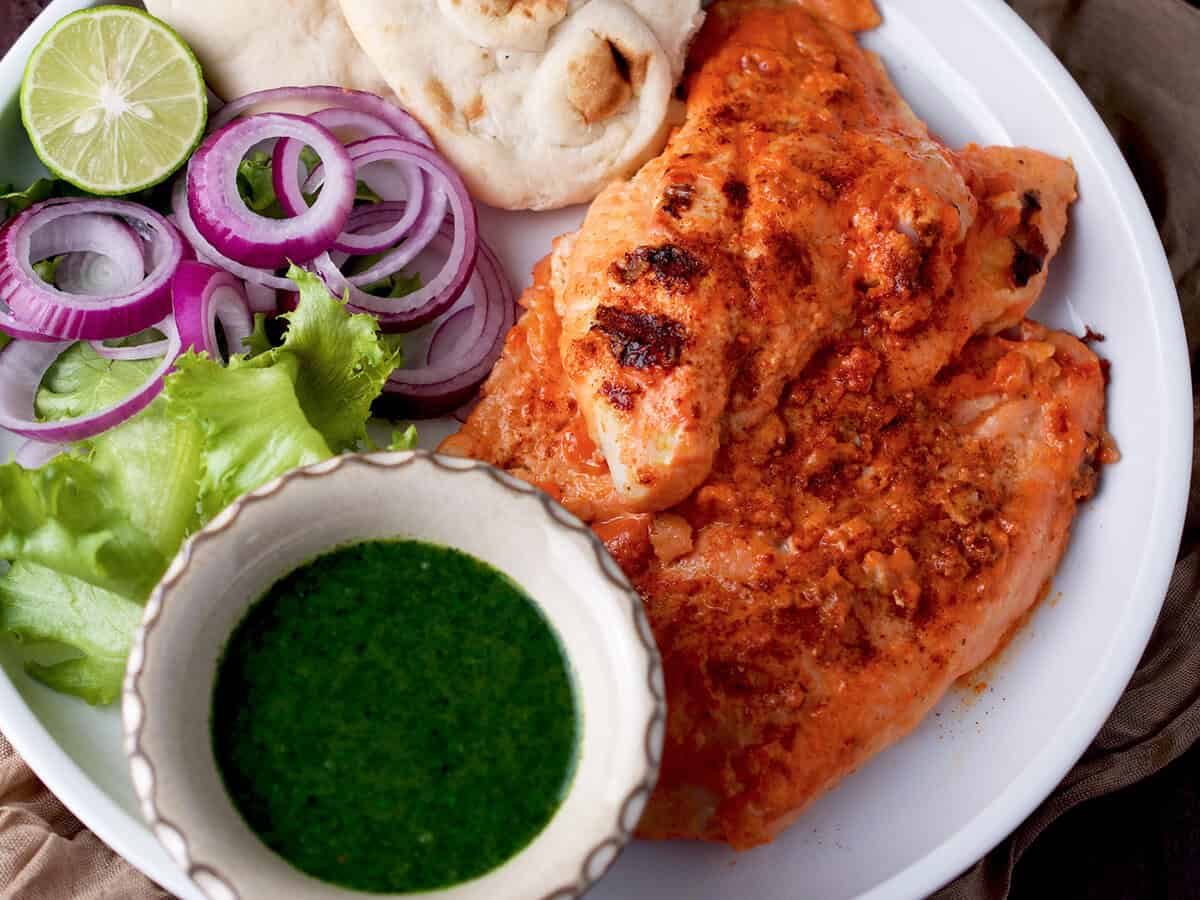 Tandoori fish with a side of chutney, salad and naan.