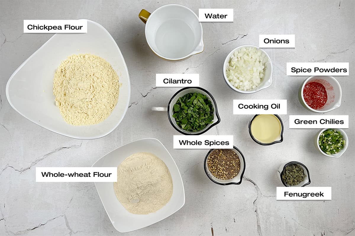 Ingredients for a missi roti recipe have been measured and set out on a white kitchen counter.