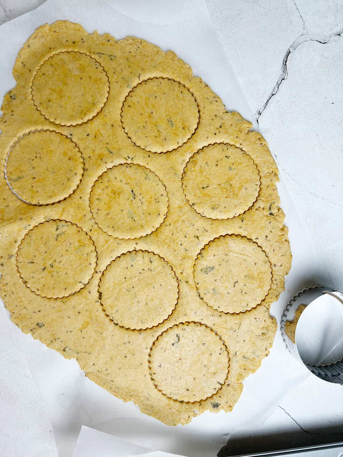 savory cornmeal tarts are being cut out using a biscuit cutter, for a recipe.