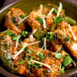 Peshawari chicken karahi in a bowl with a garnish of cilantro and ginger.