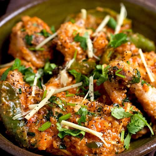 Peshawari chicken karahi in a bowl with a garnish of cilantro and ginger.