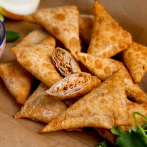 Chicken samosas with cilantro and chutney on the side.