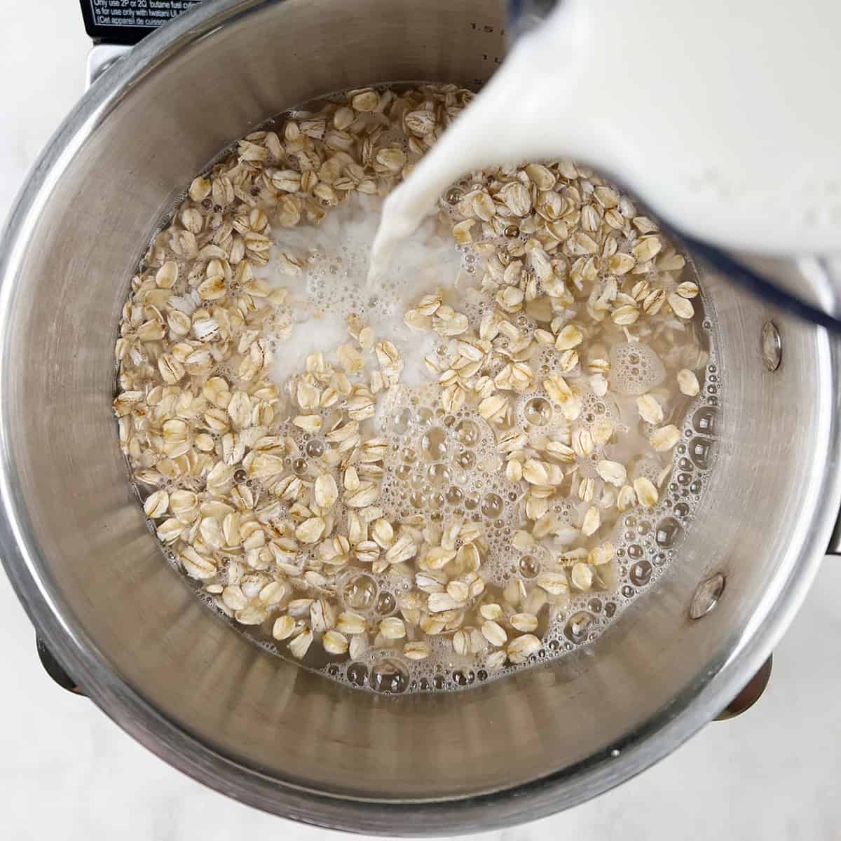 Milk is being added to a rolled oats and water mixture.