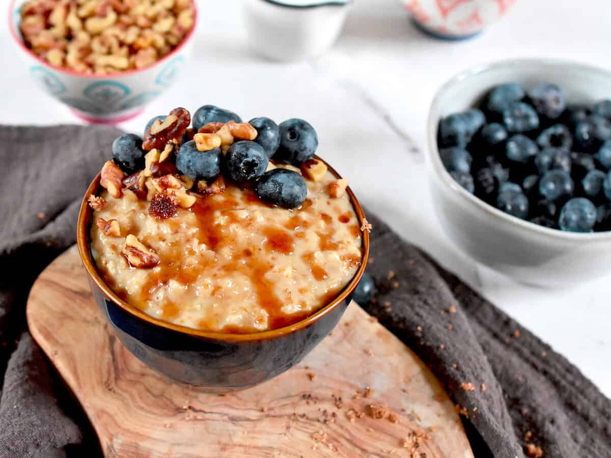 Pakistani style oatmeal is topped with jaggery, blueberries and walnuts.