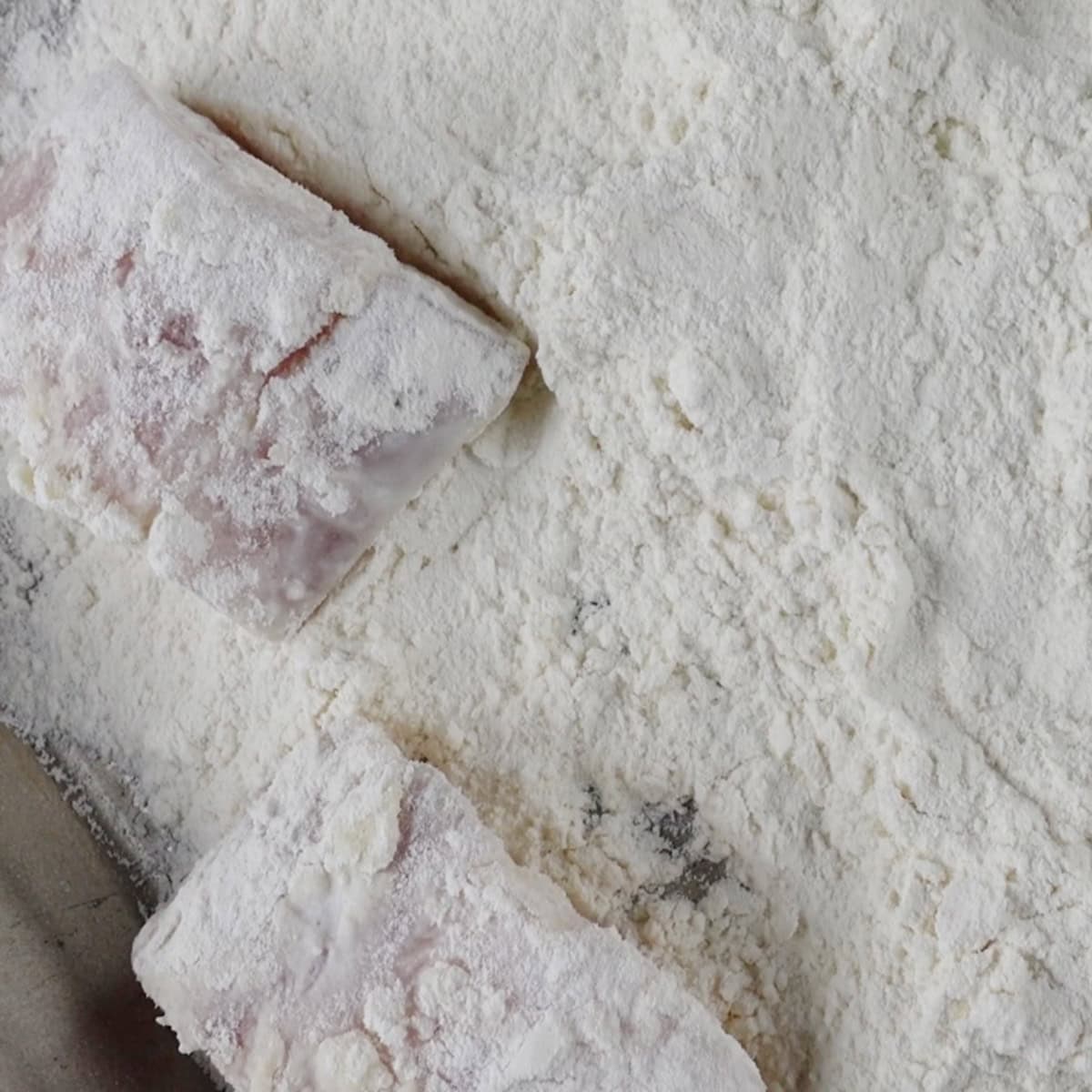 Fish being coated in flour.