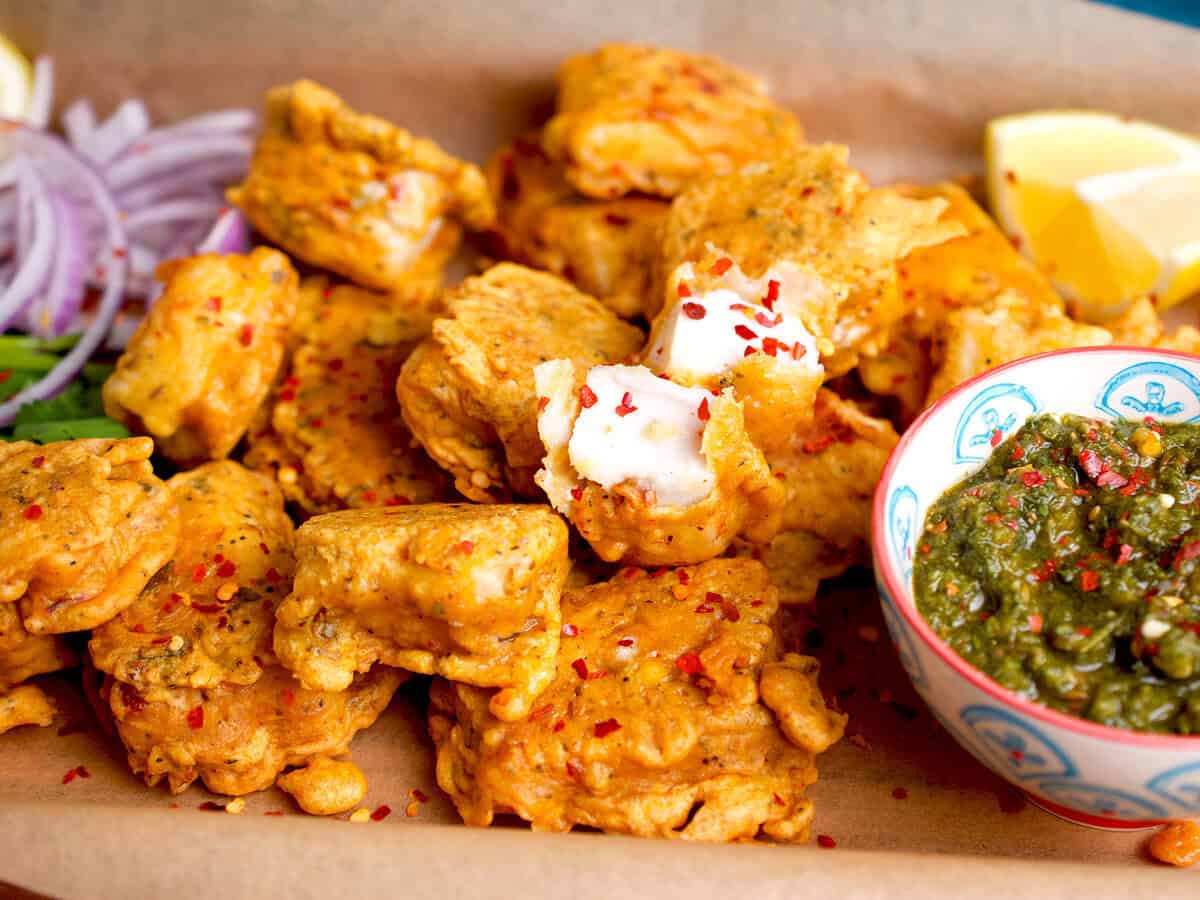 Fried fish with a side of chutney and onions.
