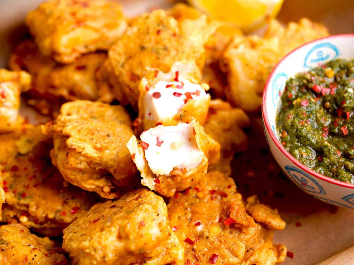 Lahori fried fish with a bowl of cilantro chutney on the side.