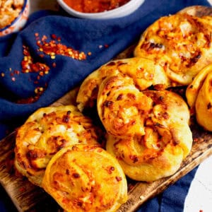 Pizza rolls with a chicken tikka filling with marinara sauce on the side.