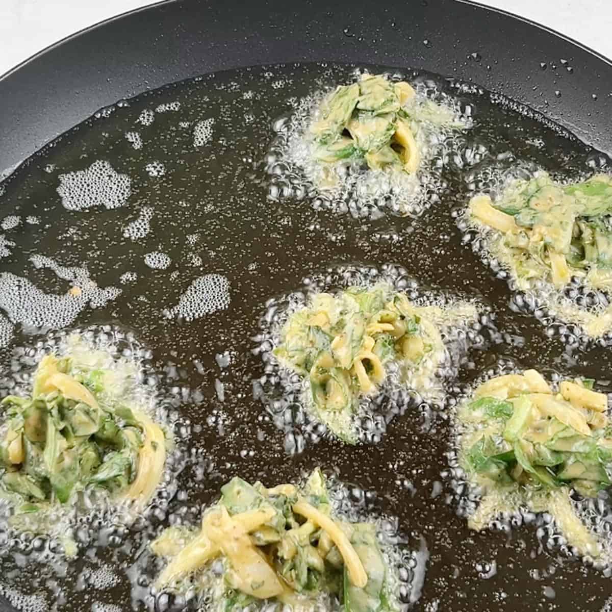 Spinach pakoras are being fried.