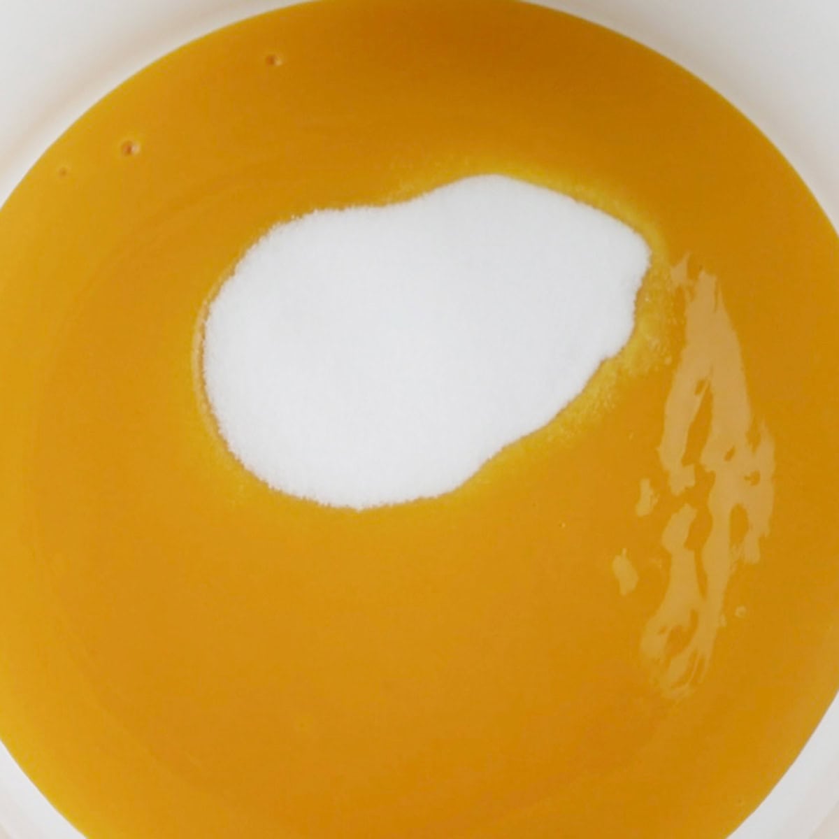 A sugar and mango mixture is being cooked.